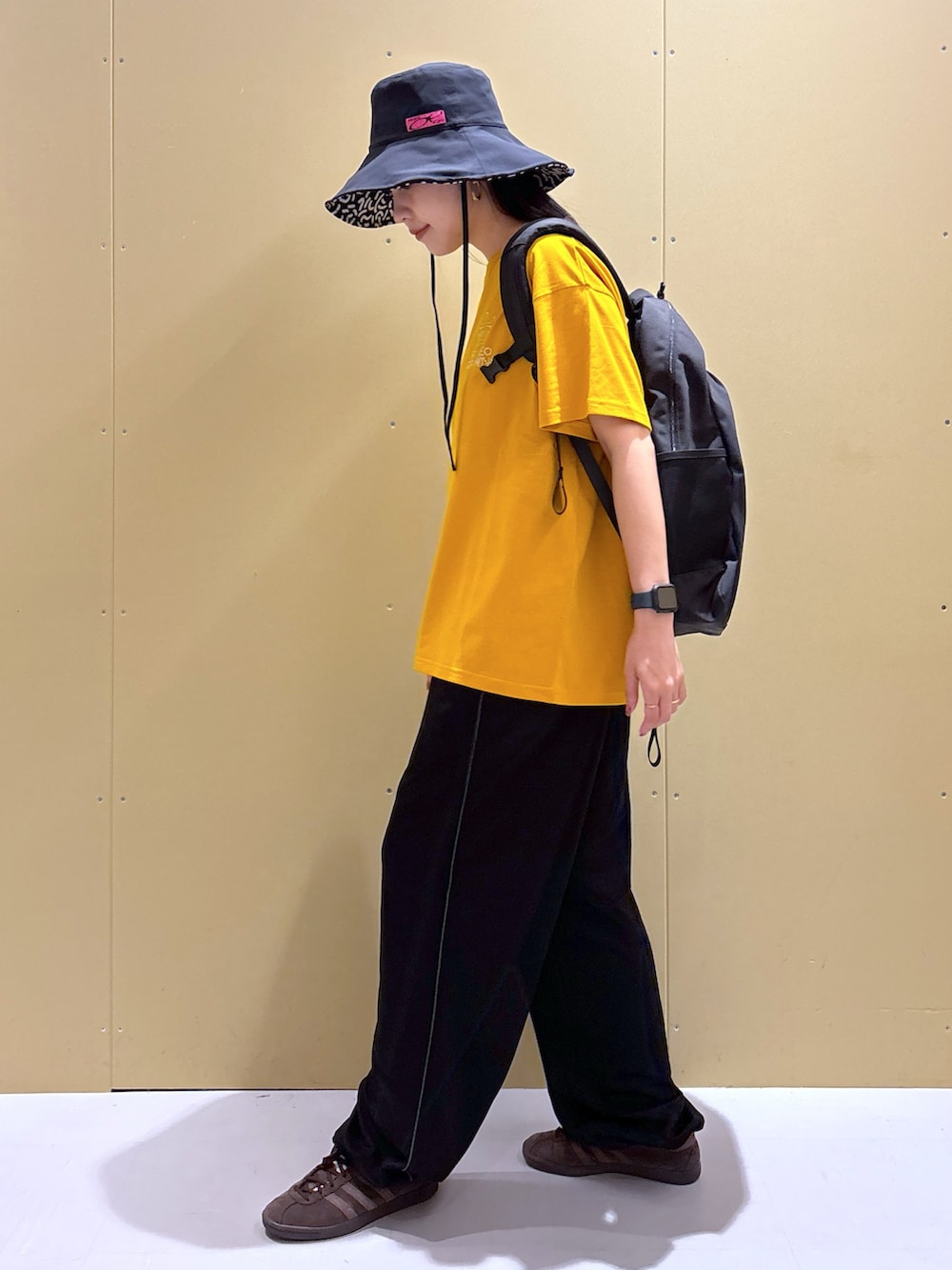 ブラック系のその他パンツ、イエロー系のTシャツ/カットソー、ブラック系のバックパック/リュックを着用したレディースの夏コーディネートの2枚目の写真