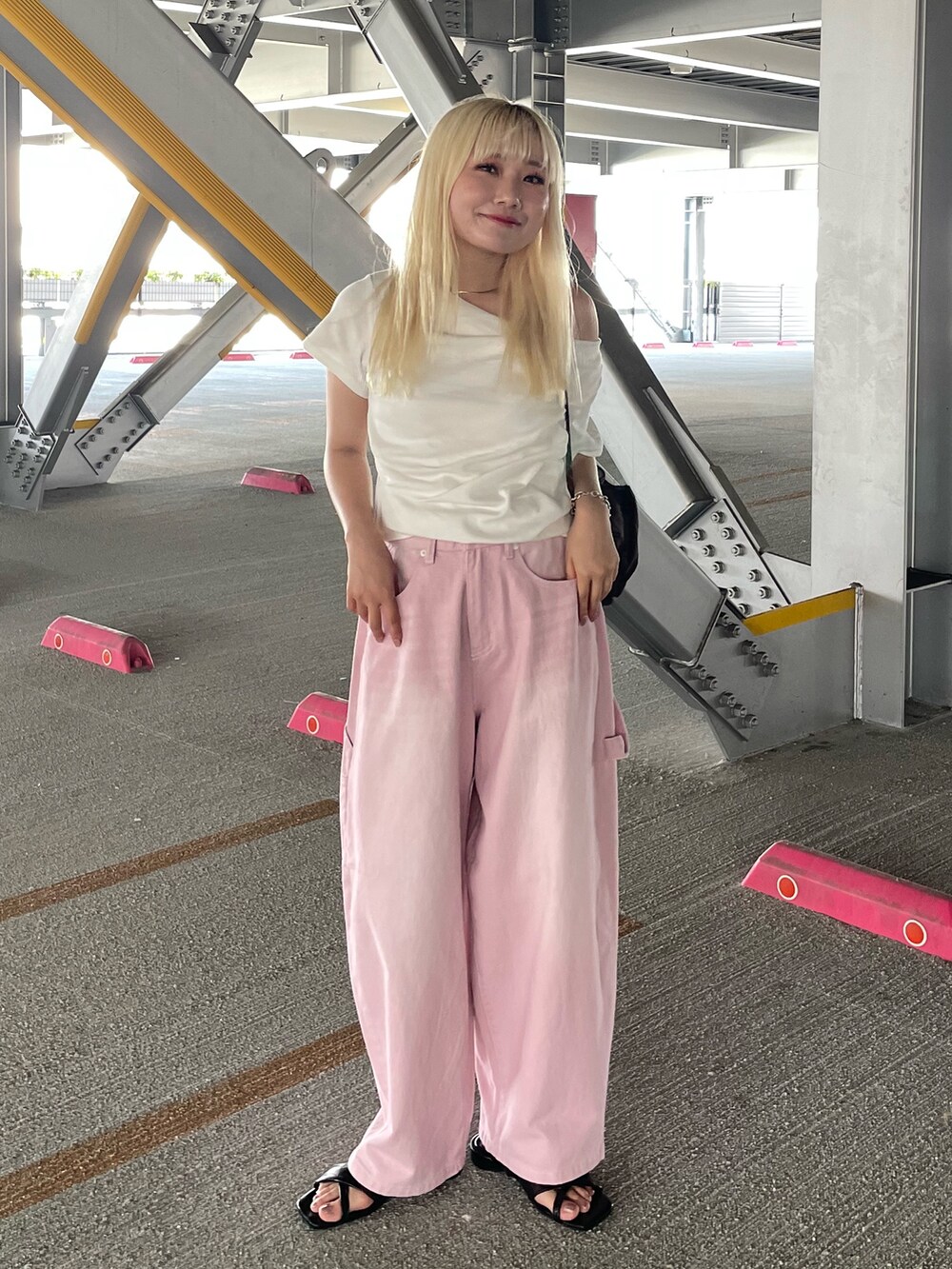 ピンク系のデニムパンツ、ホワイト系のTシャツ/カットソー、ブラウン系のバックパック/リュックを着用したレディースの夏コーディネートの2枚目の写真