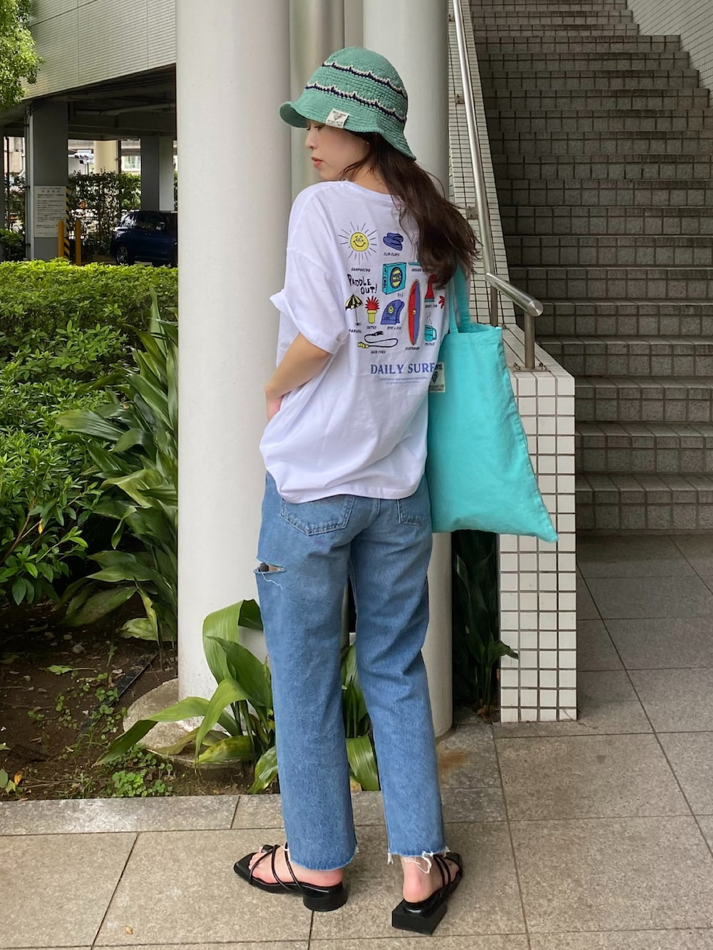 ホワイト系のTシャツ/カットソー、ブルー系のトートバッグ、グリーン系のハットを着用したレディースの夏コーディネートの3枚目の写真