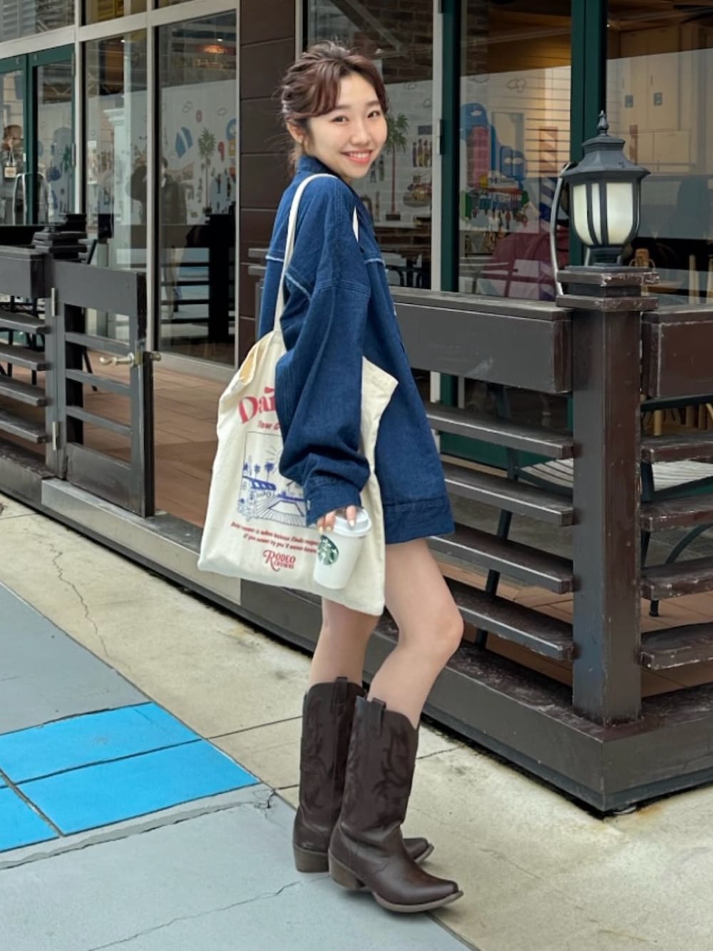ブルー系のデニムジャケット、ホワイト系のトートバッグを着用したレディースの春コーディネートの2枚目の写真
