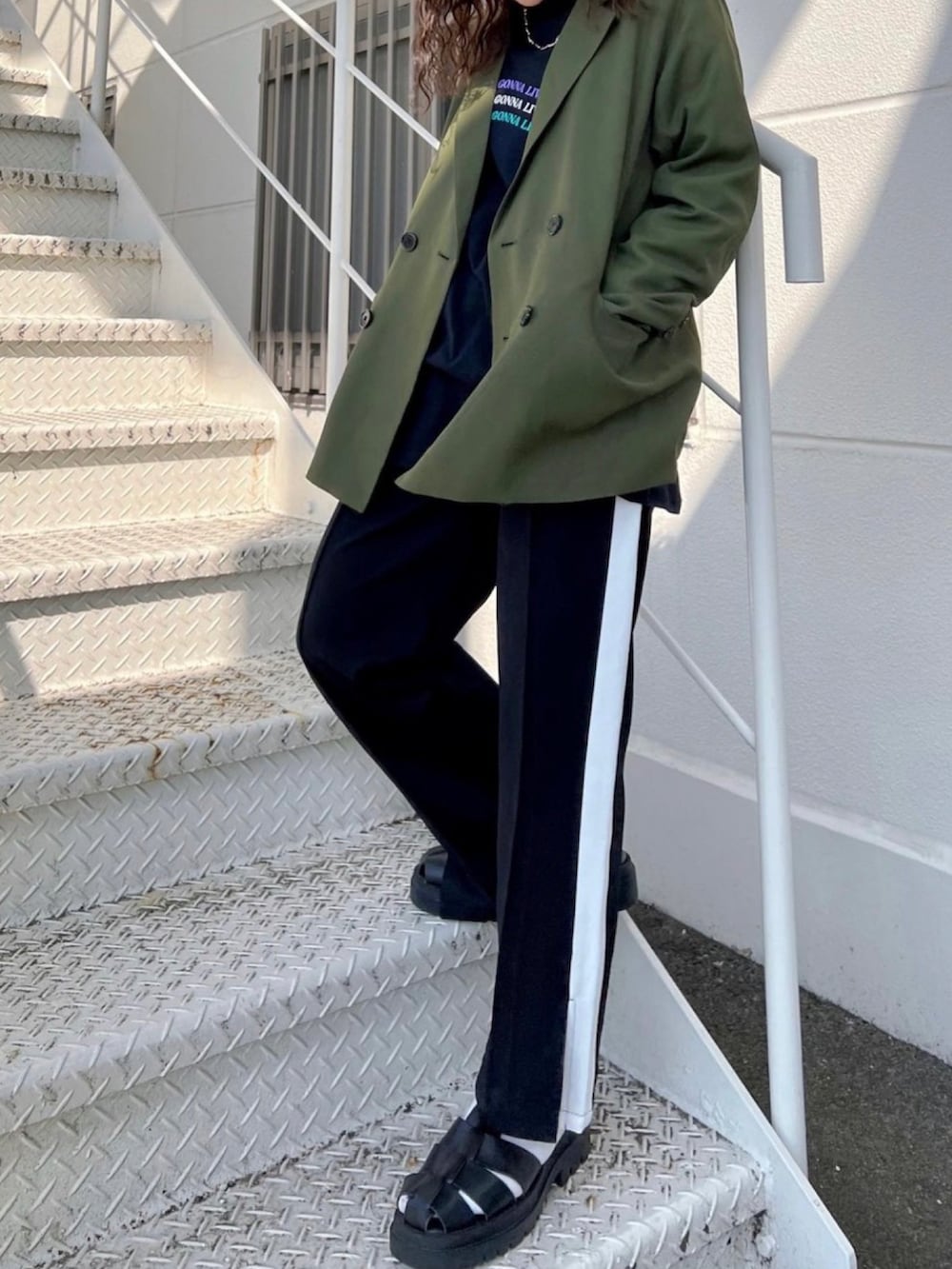 グリーン系のテーラードジャケット、ブラック系のその他パンツを着用したレディースの春コーディネートの2枚目の写真