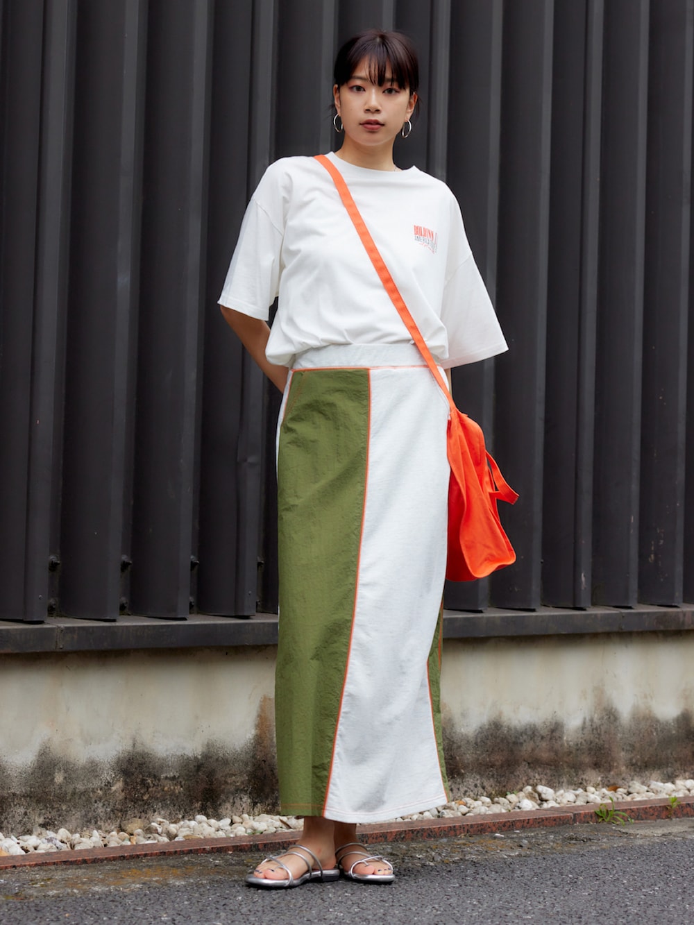 ホワイト系のTシャツ/カットソー、オレンジ系のショルダーバッグ、グリーン系のスカートを着用したレディースの夏コーディネートの2枚目の写真