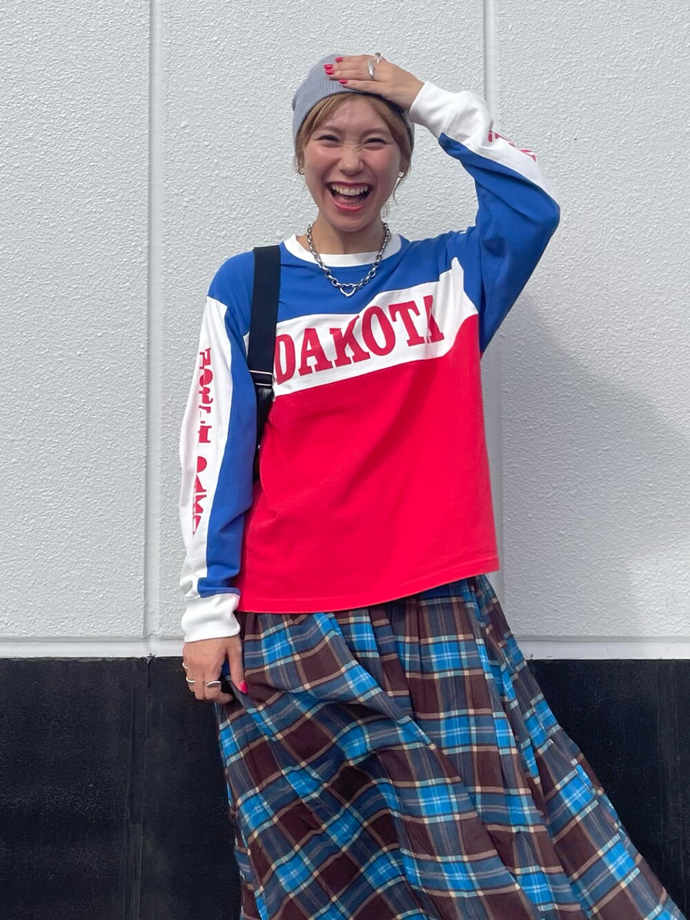 レッド系のTシャツ/カットソー、ブラック系のショルダーバッグ、ブルー系のスカートを着用したレディースの秋コーディネートの3枚目の写真