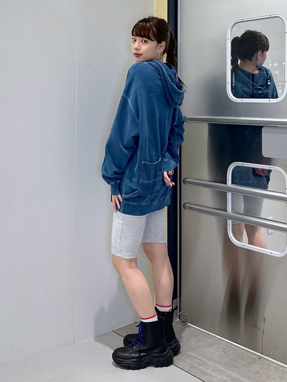 グレー系のその他パンツ、ブルー系のパーカー、ブラック系のブーツを着用したレディースの秋コーディネートの2枚目の写真