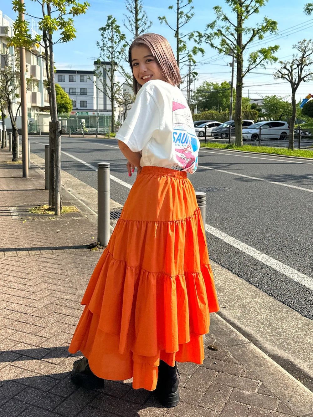 ホワイト系のTシャツ/カットソー、オレンジ系のスカートを着用したレディースの春コーディネートの2枚目の写真