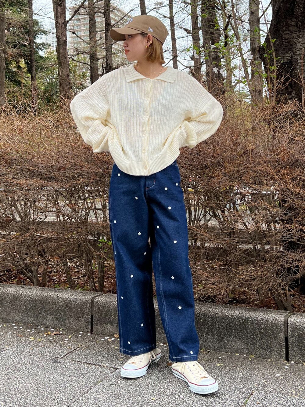 ブルー系のデニムパンツ、ホワイト系のカーディガン/ボレロ、ベージュ系のキャップを着用したレディースの春コーディネートの2枚目の写真