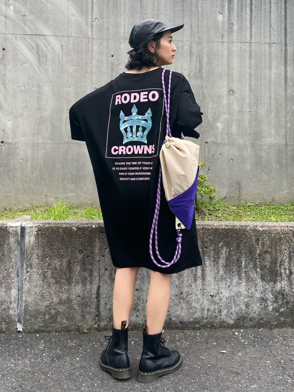 ブラック系のワンピース、ベージュ系のバックパック/リュックを着用したレディースの夏コーディネートの2枚目の写真