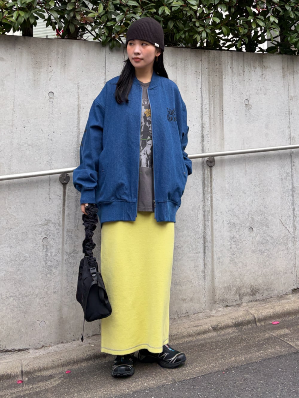 ブルー系のブルゾン、イエロー系のスカート、ブラック系のショルダーバッグを着用したレディースの冬コーディネートの3枚目の写真