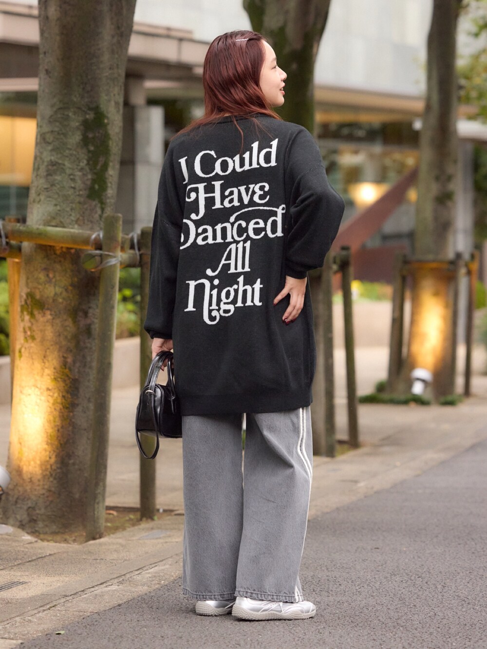 ブラック系のワンピース、ブラック系のデニムパンツ、ブラック系のショルダーバッグを着用したレディースの冬コーディネートの3枚目の写真