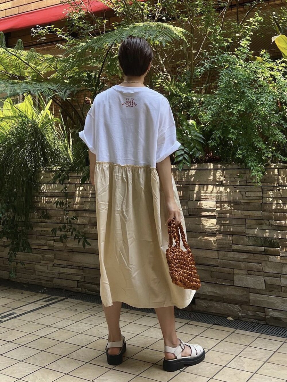 ホワイト系のワンピース、イエロー系のハンドバッグを着用したレディースの夏コーディネートの2枚目の写真