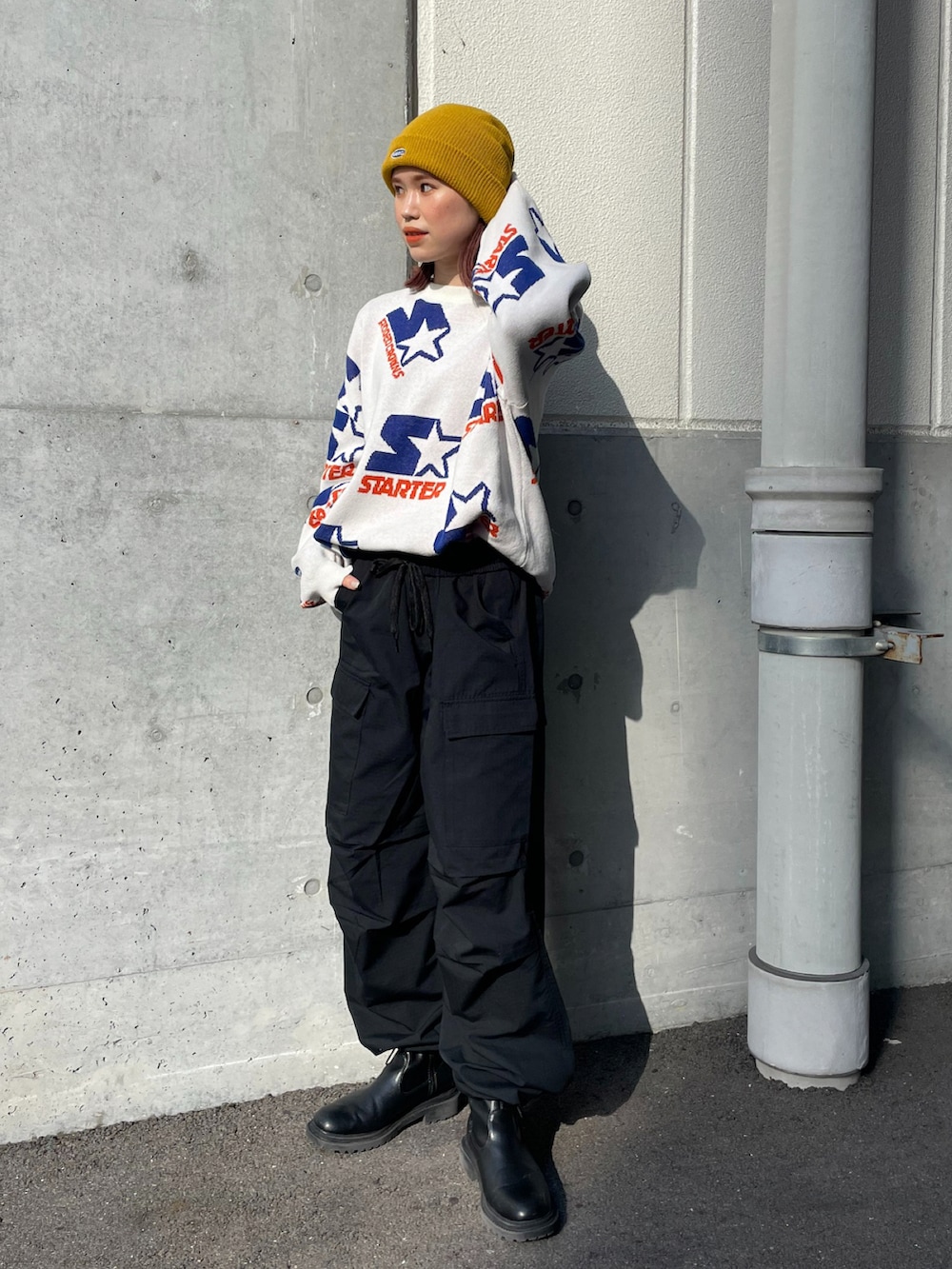 ホワイト系のニット/セーター、ブラック系のカーゴパンツ、イエロー系のニットキャップ/ビーニーを着用したレディースの冬コーディネートの2枚目の写真