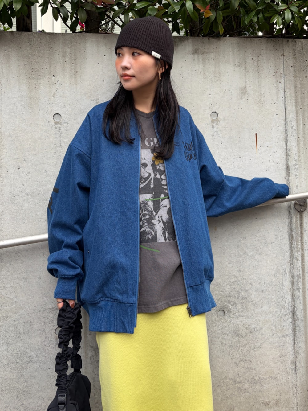 ブルー系のブルゾン、イエロー系のスカート、ブラック系のショルダーバッグを着用したレディースの冬コーディネートの2枚目の写真