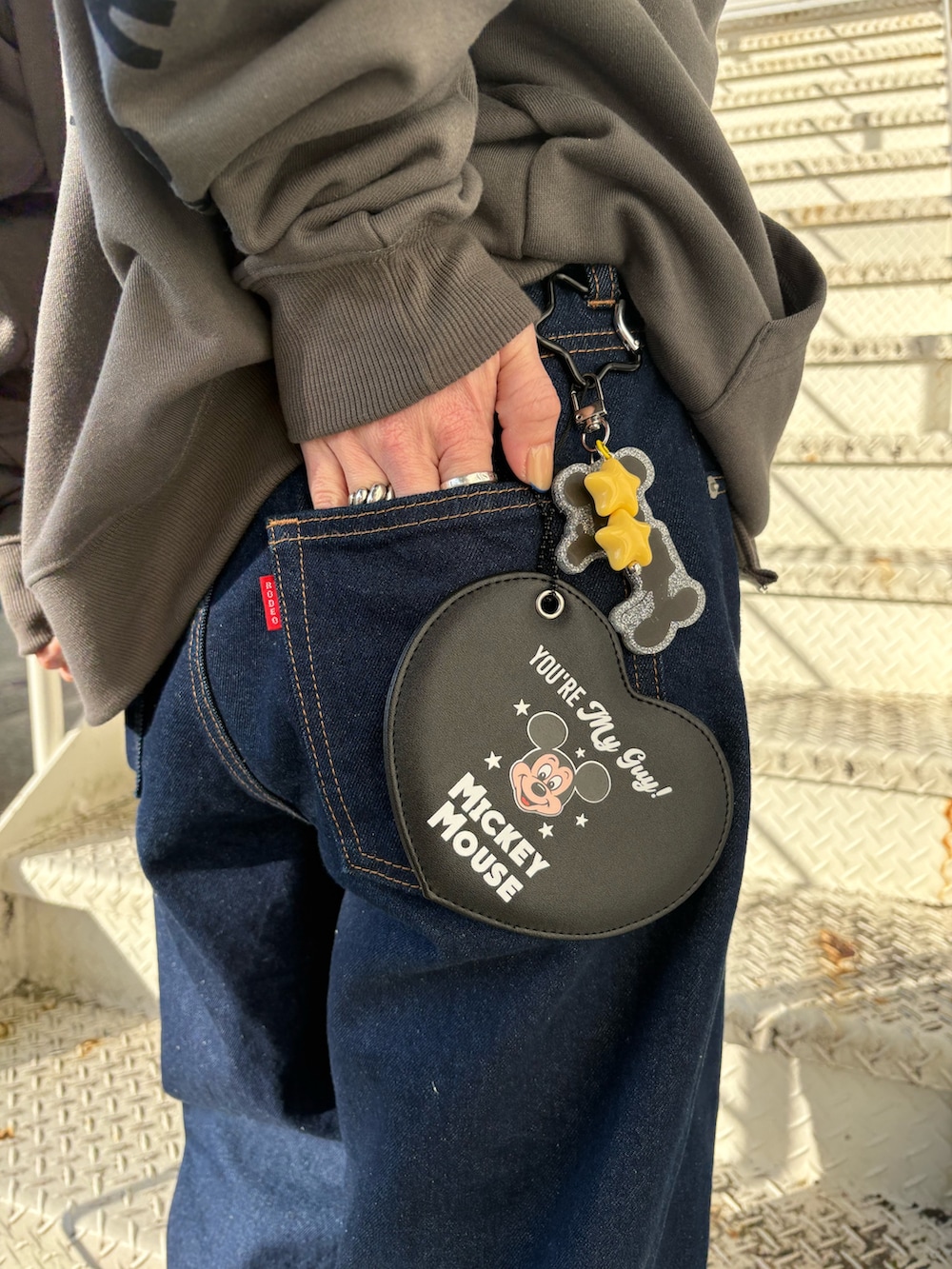 グレー系のパーカー、ブラック系のチャームを着用したレディースの冬コーディネートの3枚目の写真