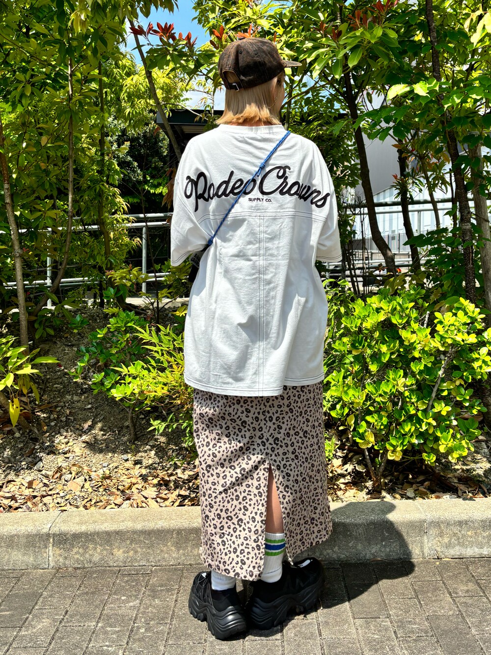 ホワイト系のTシャツ/カットソー、ベージュ系のスカート、ブラック系のショルダーバッグを着用したレディースの春コーディネートの2枚目の写真