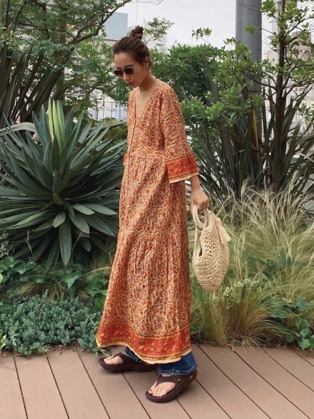 オレンジ系のワンピース、ホワイト系のショルダーバッグを着用したレディースの夏コーディネートの2枚目の写真