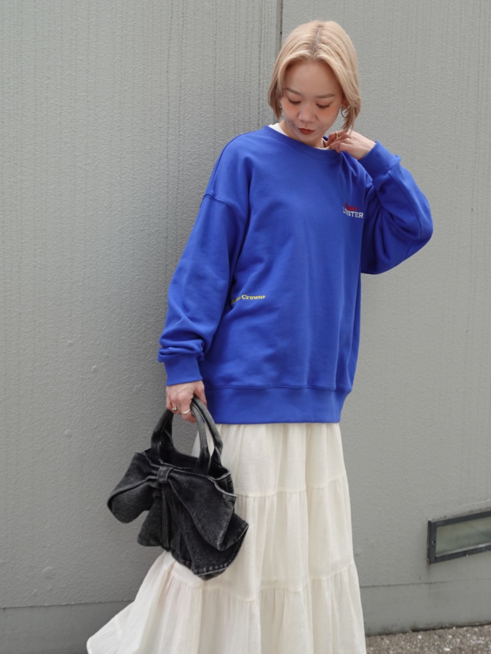 ブルー系のスウェット、ホワイト系のスカートを着用したレディースの冬コーディネートの2枚目の写真