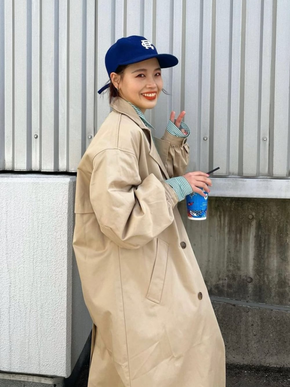 ベージュ系のトレンチコート、ブラック系のその他パンツを着用したレディースの春コーディネートの2枚目の写真