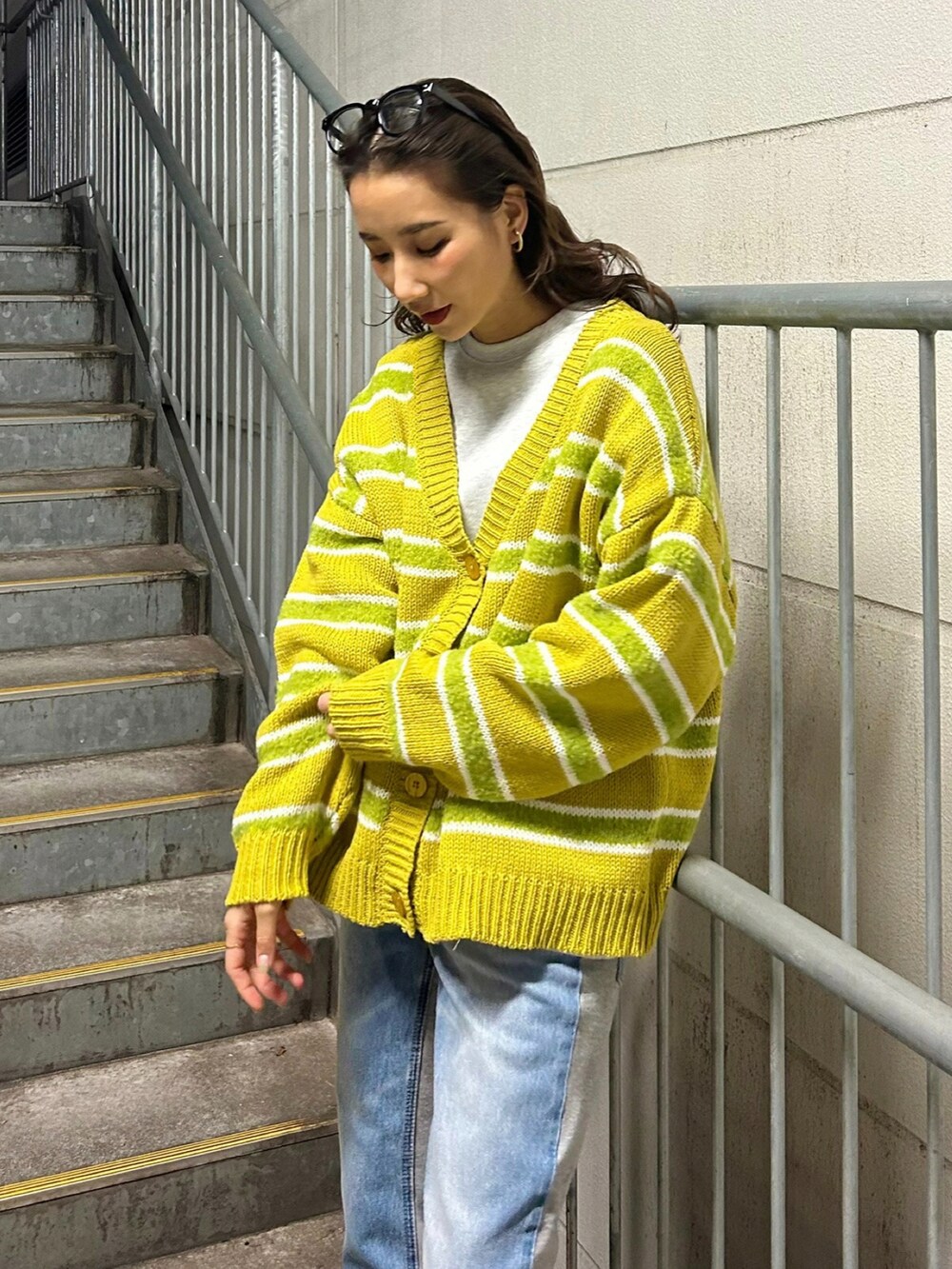 ブルー系のデニムパンツ、イエロー系のカーディガン/ボレロ、グレー系のスウェットを着用したレディースの冬コーディネートの2枚目の写真