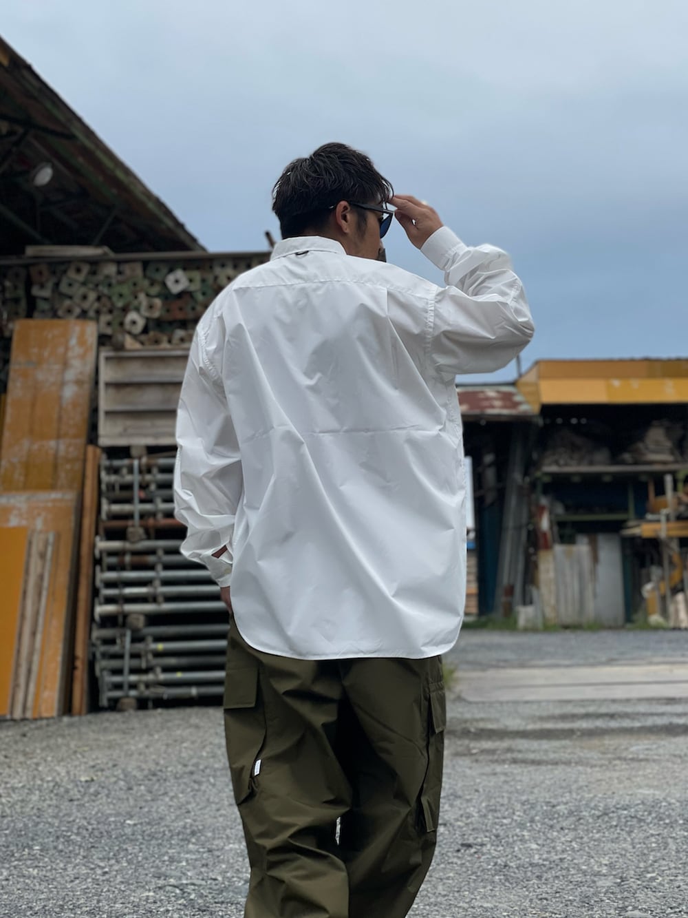 グリーン系のその他パンツ、ホワイト系のシャツ/ブラウス、ブラウン系のモカシン/デッキシューズを着用したメンズの秋コーディネートの3枚目の写真