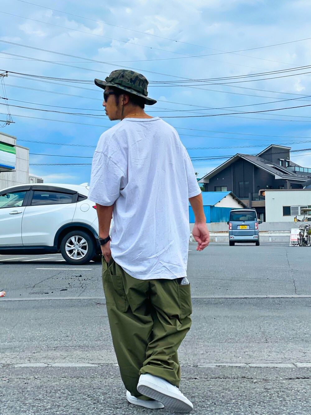 グレー系のTシャツ/カットソー、グリーン系のパンツ、ホワイト系のシューズを着用したメンズの夏コーディネートの3枚目の写真