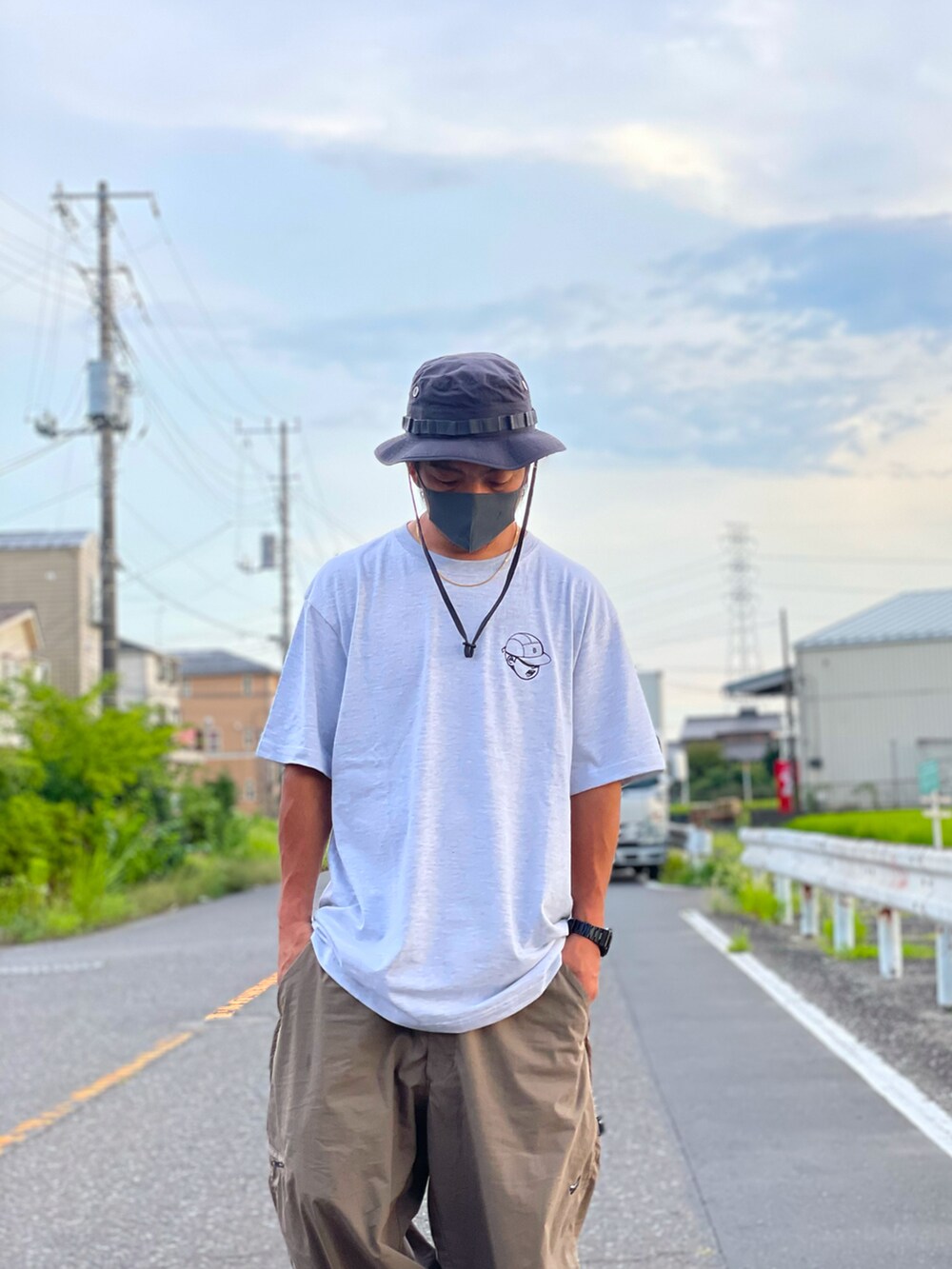 ホワイト系のトップス、グリーン系のパンツ、ホワイト系のスニーカーを着用したメンズの夏コーディネートの2枚目の写真