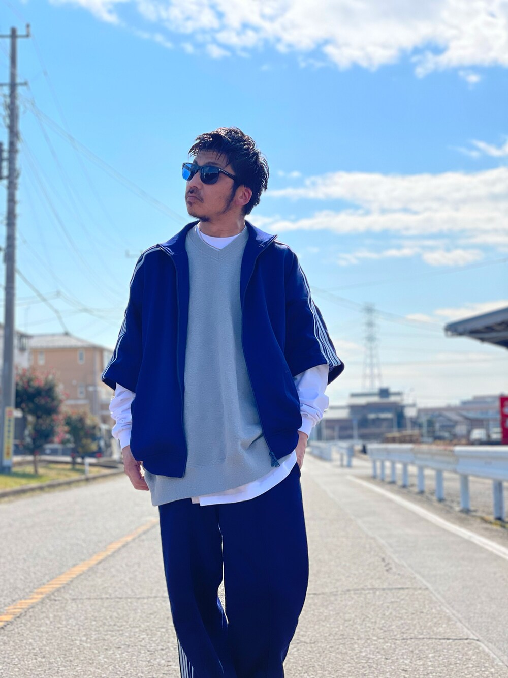 グレー系のベスト、ホワイト系のトップス、ブルー系のスウェットパンツを着用したメンズの冬コーディネートの3枚目の写真