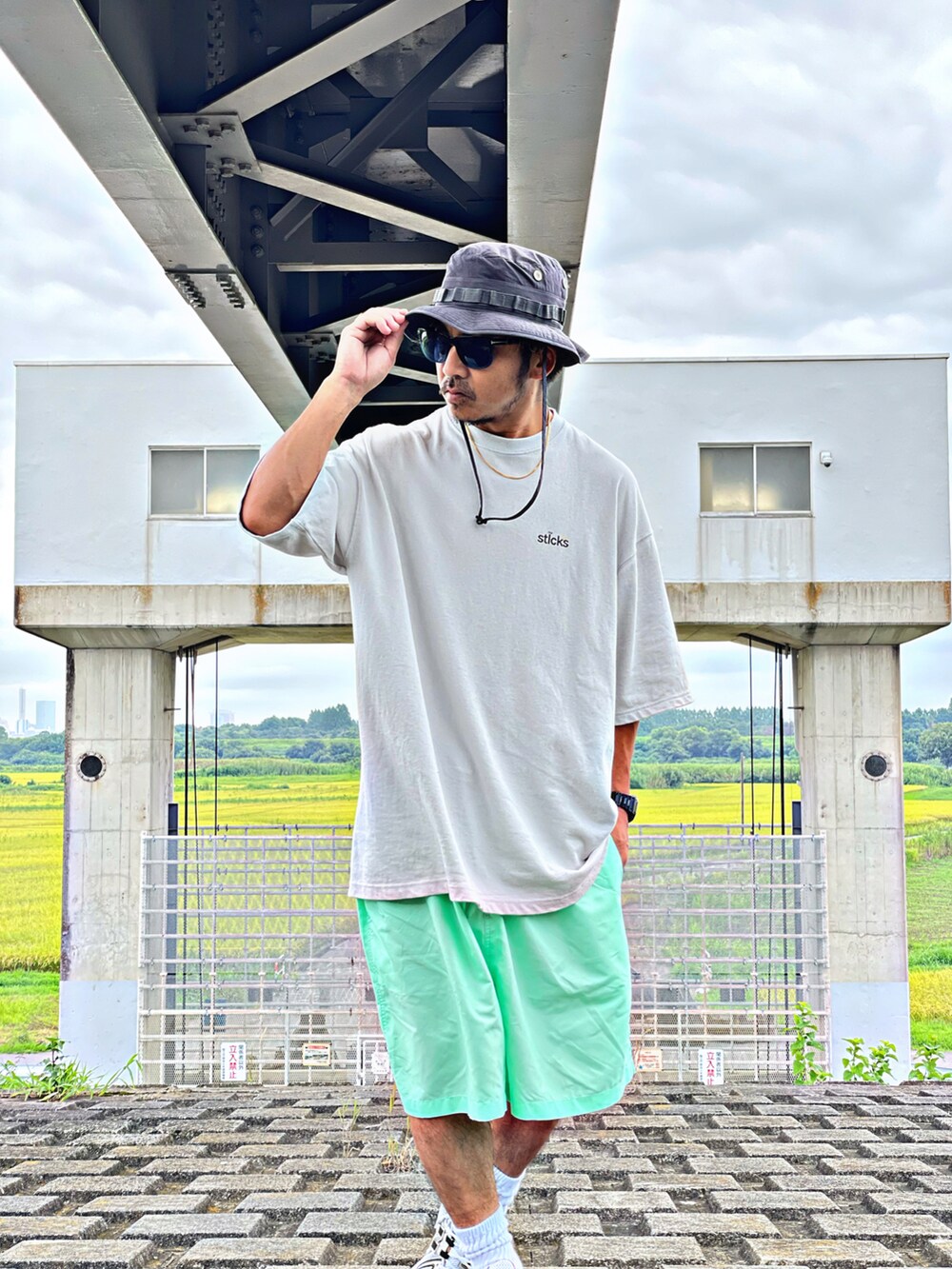 グリーン系のその他パンツ、ベージュ系のTシャツ/カットソー、イエロー系のスニーカーを着用したメンズの夏コーディネートの2枚目の写真