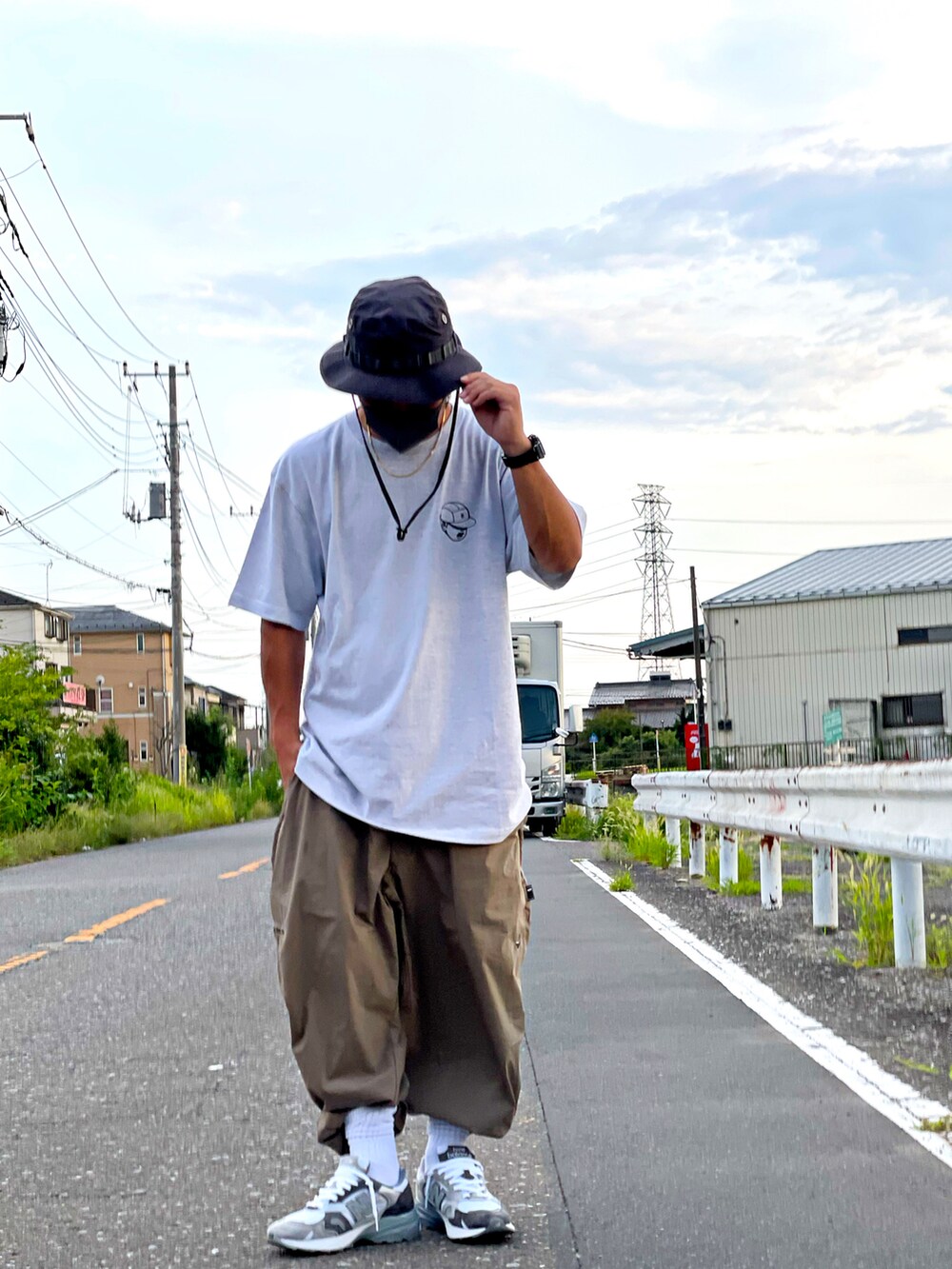 ホワイト系のトップス、グリーン系のパンツ、ホワイト系のスニーカーを着用したメンズの夏コーディネートの3枚目の写真