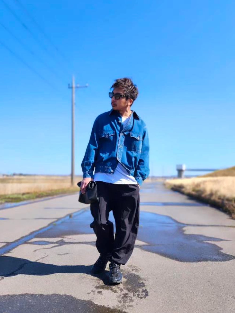 ブルー系のデニムジャケット、ホワイト系のTシャツ/カットソー、ブラック系のパンツを着用したメンズの春コーディネートの2枚目の写真