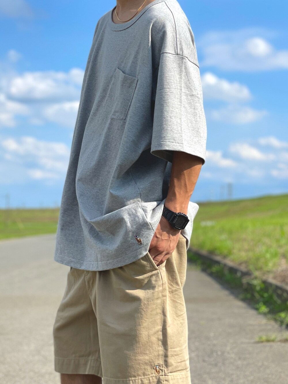 ベージュ系のパンツ、グレー系のスニーカー、グレー系のTシャツ/カットソーを着用したメンズの春コーディネートの2枚目の写真