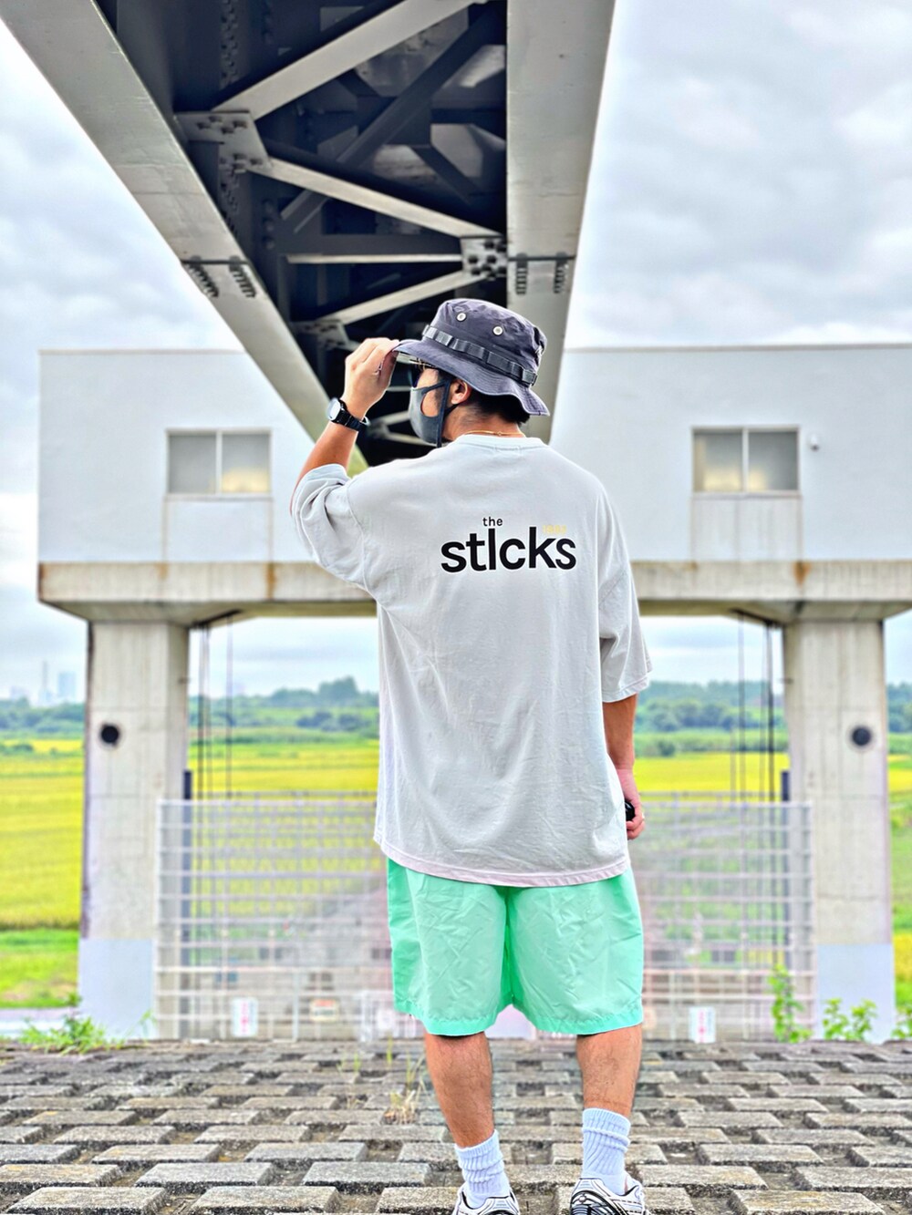 グリーン系のその他パンツ、ベージュ系のTシャツ/カットソー、イエロー系のスニーカーを着用したメンズの夏コーディネートの3枚目の写真