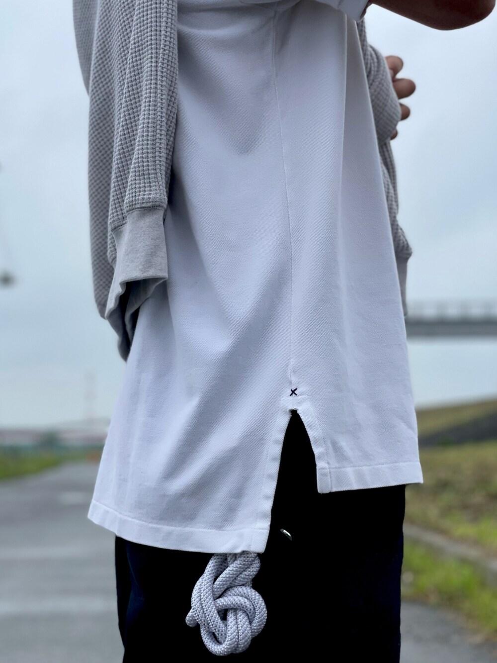 グレー系のスウェット、ホワイト系のポロシャツ、ブルー系のチノパンツを着用したメンズの春コーディネートの2枚目の写真