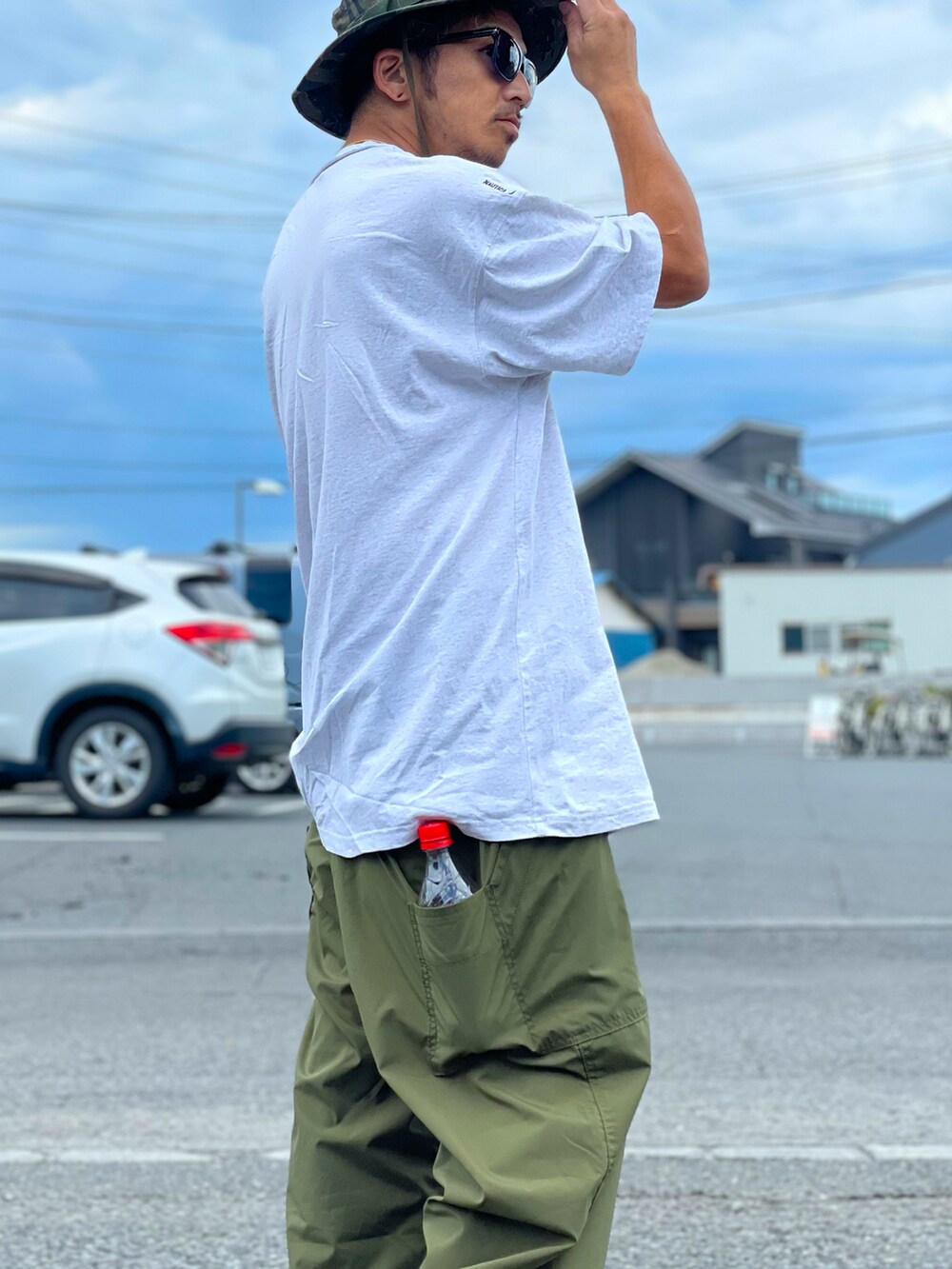 グレー系のTシャツ/カットソー、グリーン系のパンツ、ホワイト系のシューズを着用したメンズの夏コーディネートの2枚目の写真