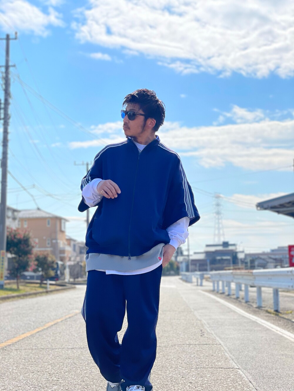 グレー系のベスト、ホワイト系のトップス、ブルー系のスウェットパンツを着用したメンズの冬コーディネートの2枚目の写真