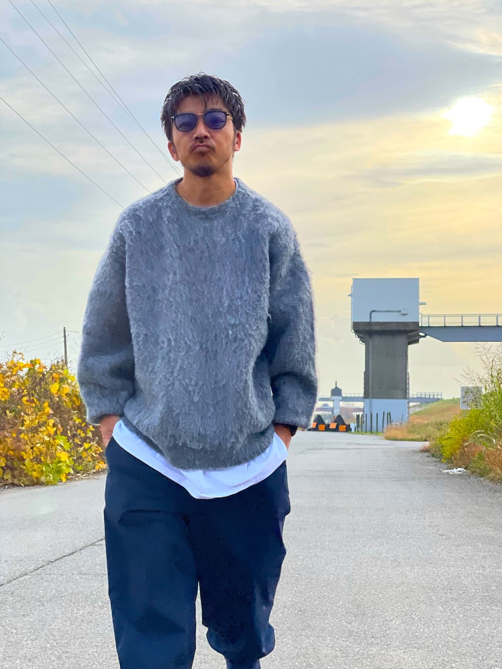 ブルー系のダウンジャケット/コート、グレー系のニット/セーター、ブラック系のその他パンツを着用したメンズの秋コーディネートの3枚目の写真