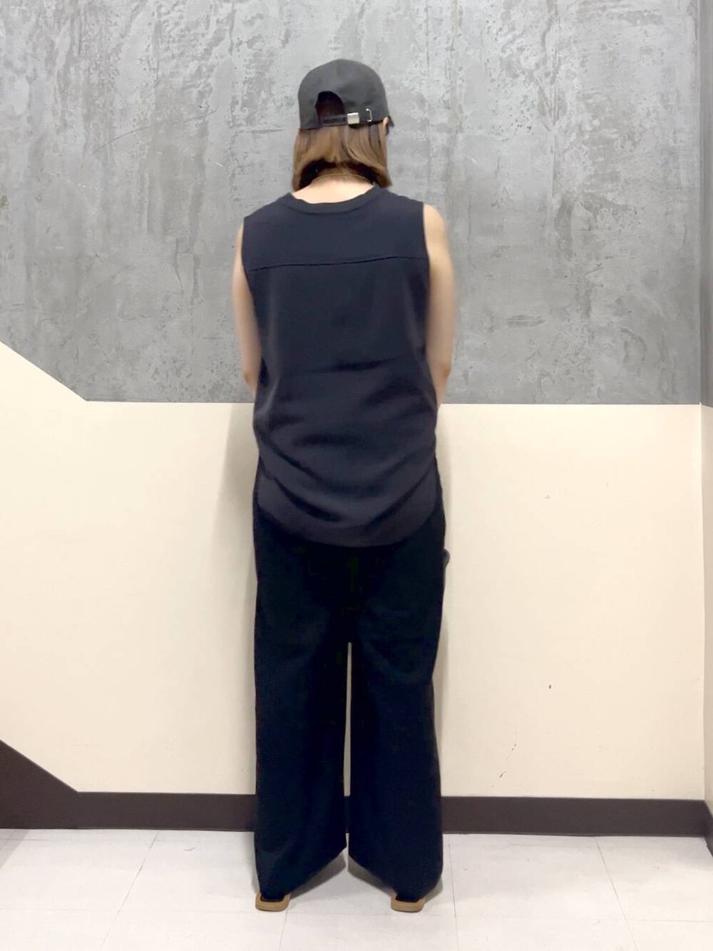 グレー系のトートバッグ、グレー系のTシャツ/カットソー、ブラック系のスラックスを着用したレディースの夏コーディネートの3枚目の写真