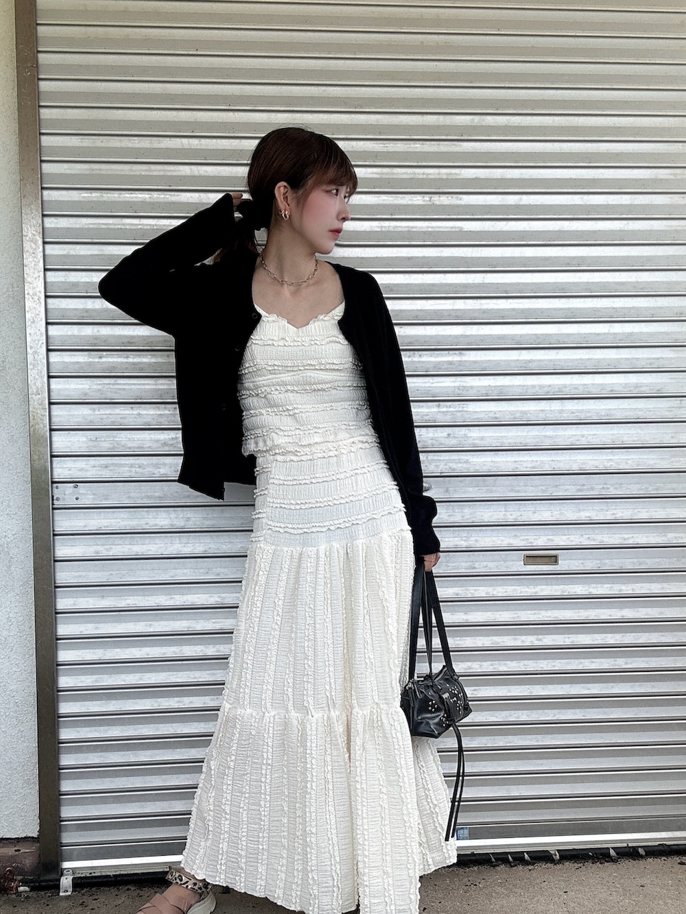 ブラック系のショルダーバッグ、ピンク系のサンダル、ブラック系のカーディガン/ボレロを着用したレディースの秋コーディネートの2枚目の写真