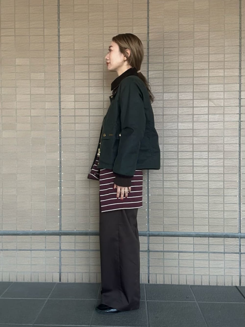 グリーン系のブルゾン、ホワイト系のTシャツ/カットソー、ブラウン系のその他パンツを着用したレディースの秋コーディネートの2枚目の写真