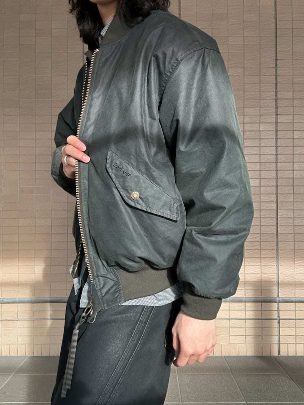 グリーン系のMA-1、グレー系のシャツ/ブラウス、ブラック系のニットキャップ/ビーニーを着用したレディースの冬コーディネートの5枚目の写真