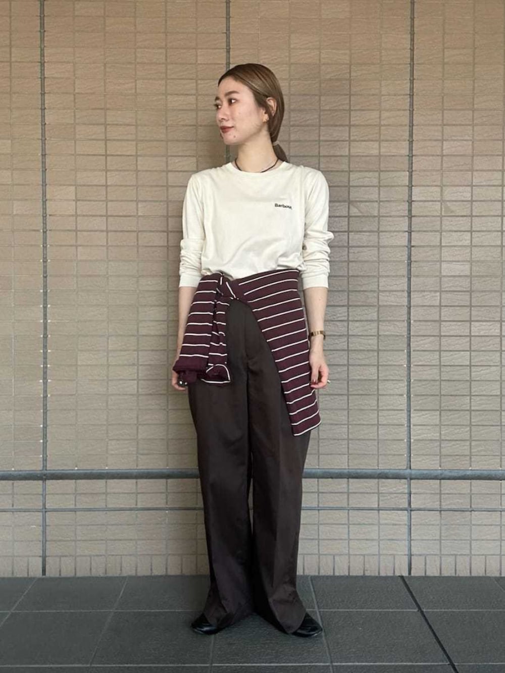 グリーン系のブルゾン、ホワイト系のTシャツ/カットソー、ブラウン系のその他パンツを着用したレディースの秋コーディネートの6枚目の写真