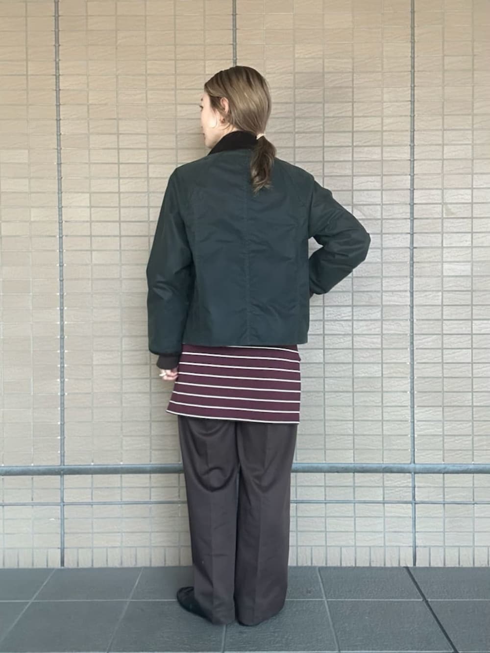 グリーン系のブルゾン、ホワイト系のTシャツ/カットソー、ブラウン系のその他パンツを着用したレディースの秋コーディネートの3枚目の写真