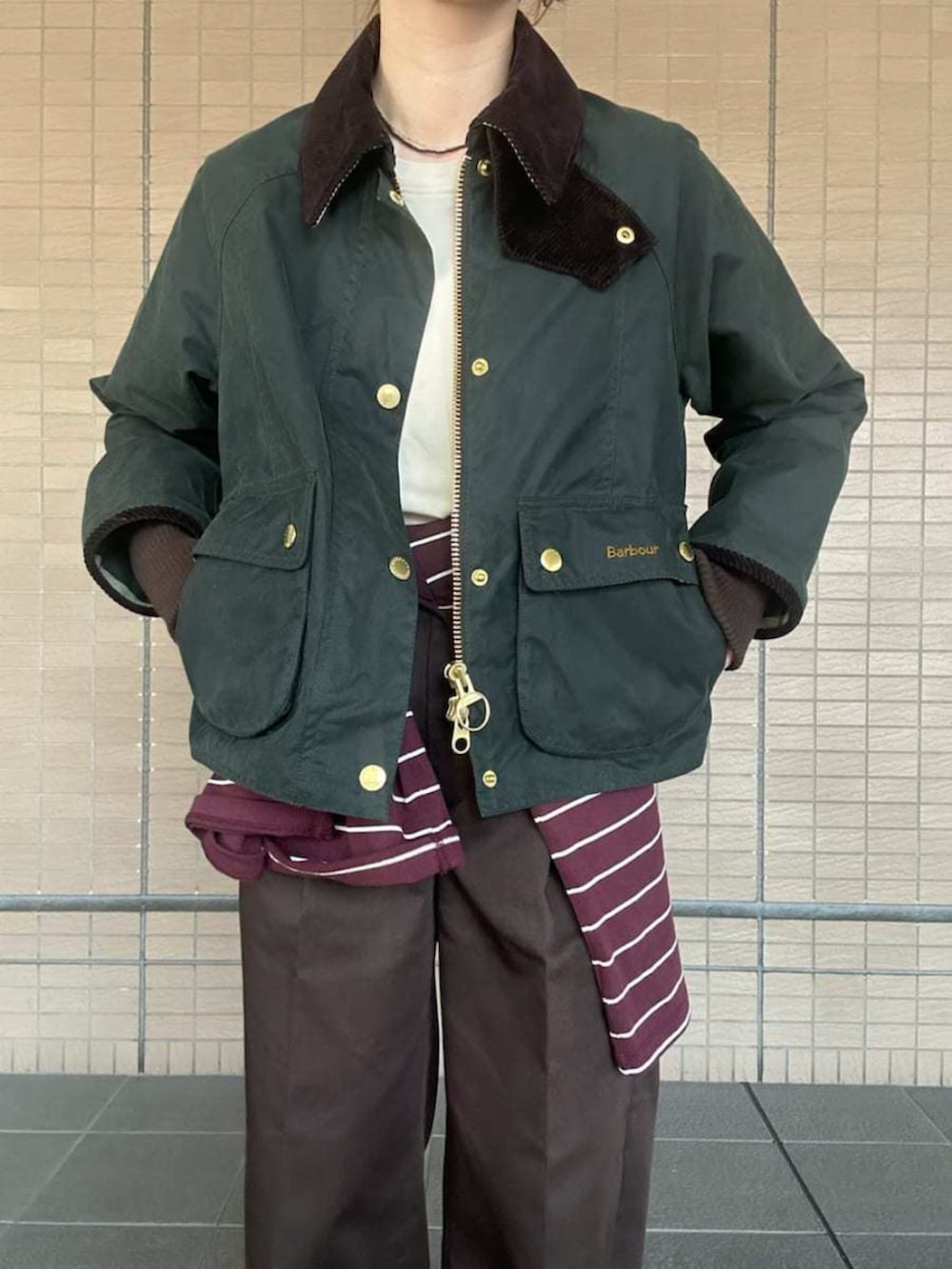 グリーン系のブルゾン、ホワイト系のTシャツ/カットソー、ブラウン系のその他パンツを着用したレディースの秋コーディネートの4枚目の写真