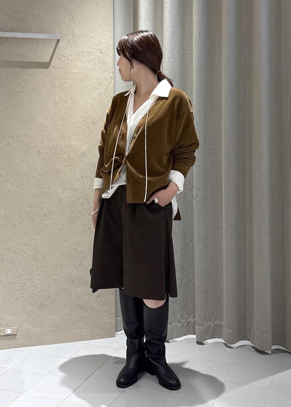 ホワイト系のシャツ/ブラウス、イエロー系のカーディガン/ボレロ、ブラック系のブーツを着用したレディースの秋コーディネートの4枚目の写真