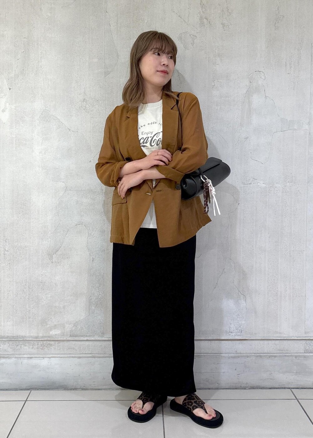 ブラック系のショルダーバッグ、ブラック系のスカート、イエロー系のテーラードジャケットを着用したレディースの夏コーディネートの2枚目の写真