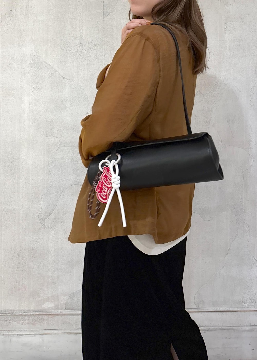 ブラック系のショルダーバッグ、ブラック系のスカート、イエロー系のテーラードジャケットを着用したレディースの夏コーディネートの6枚目の写真