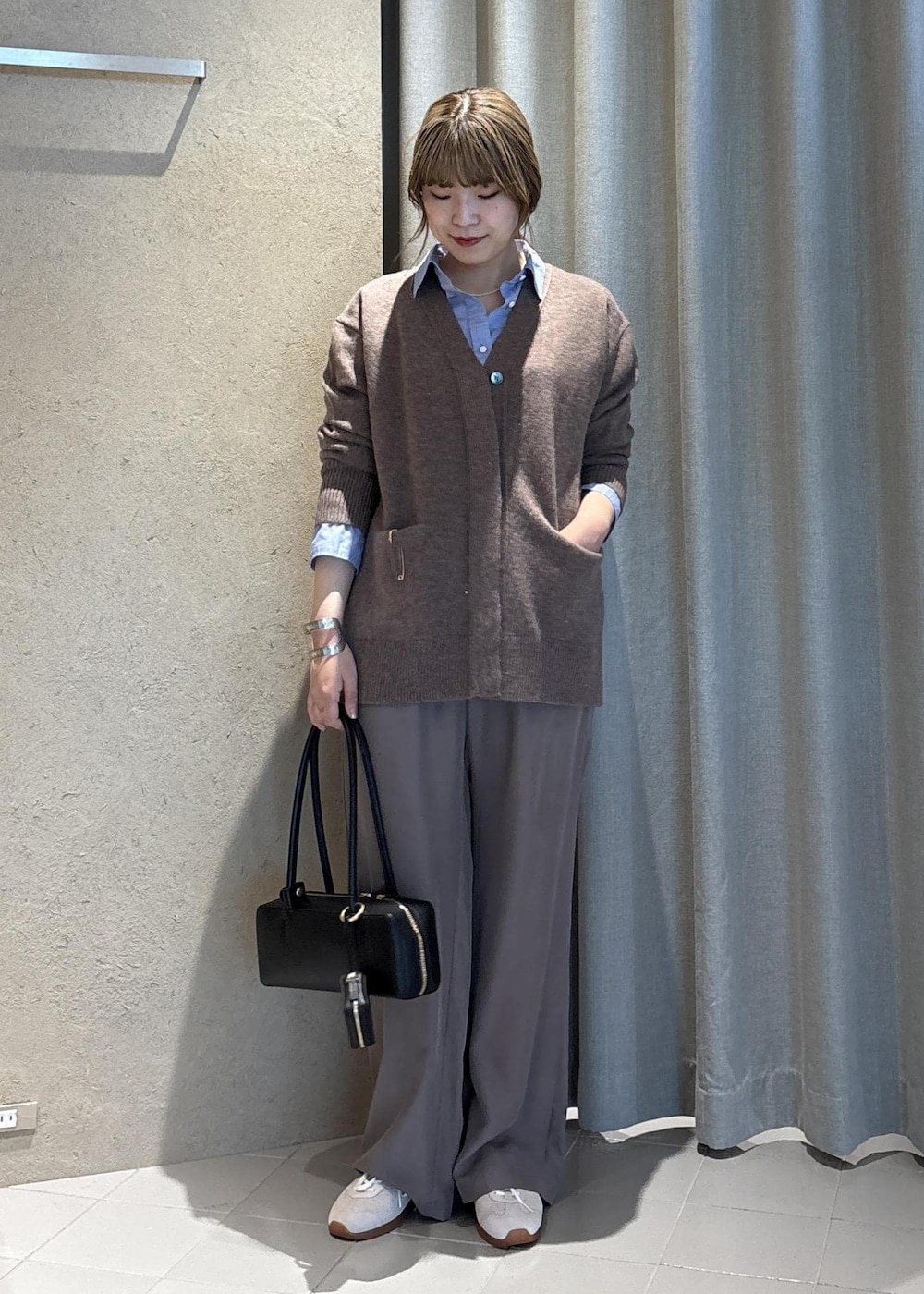 ブラック系のショルダーバッグ、ブルー系のシャツ/ブラウス、ブラウン系のその他パンツを着用したレディースの冬コーディネートの2枚目の写真