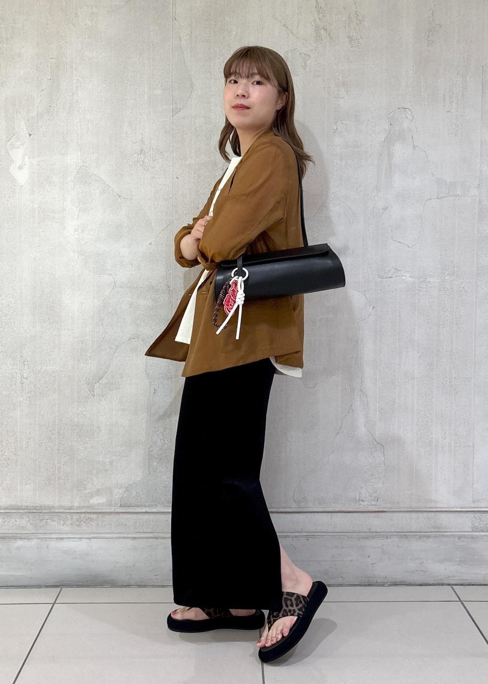 ブラック系のショルダーバッグ、ブラック系のスカート、イエロー系のテーラードジャケットを着用したレディースの夏コーディネートの4枚目の写真