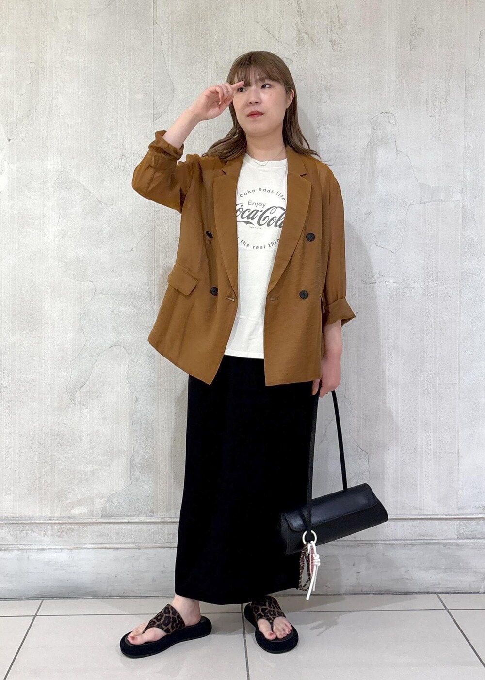 ブラック系のショルダーバッグ、ブラック系のスカート、イエロー系のテーラードジャケットを着用したレディースの夏コーディネートの3枚目の写真