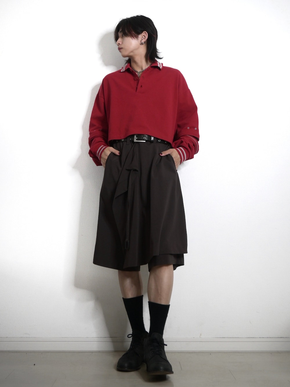 レッド系のポロシャツ、ブラウン系のパンツ、ブラック系のシューズを着用したメンズの夏コーディネートの2枚目の写真