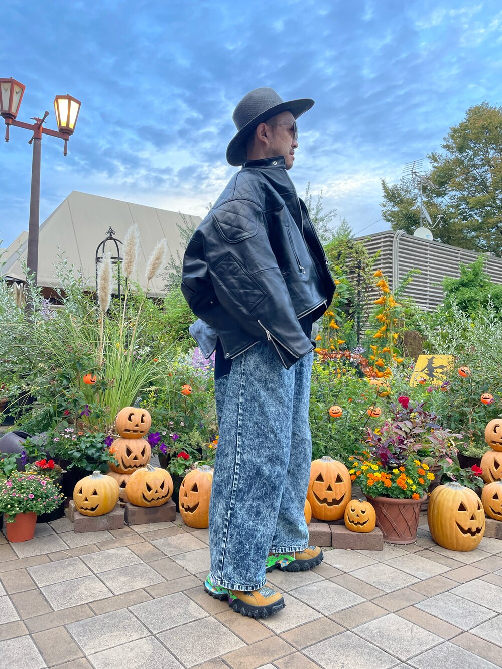 ブルー系のデニムパンツ、その他のスニーカー、ブラック系のライダースジャケットを着用したメンズの秋コーディネートの3枚目の写真